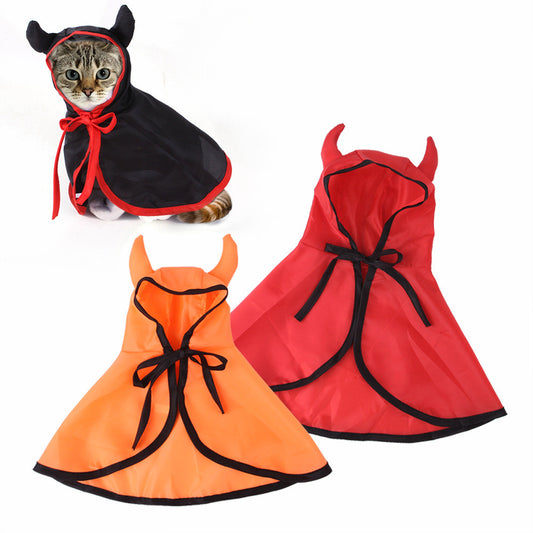 Cat in a black hooded cape with red trim and horns, alongside two capes in red and orange, each with devilish horns, perfect for a Halloween pet costume.