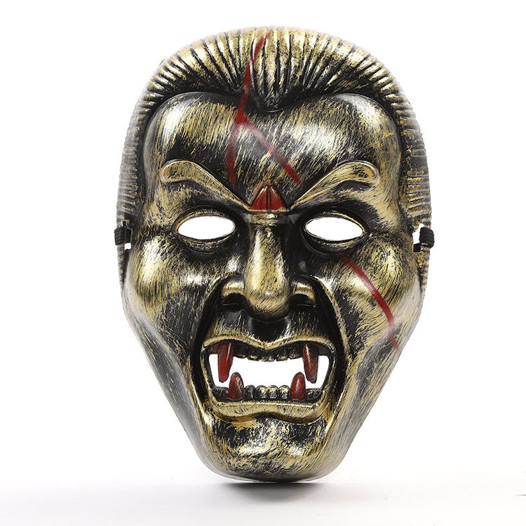 A fierce, metallic vampire mask with red scars, pointed ears, exaggerated fangs, and furrowed brows, conveying an aggressive and menacing expression against a white background.