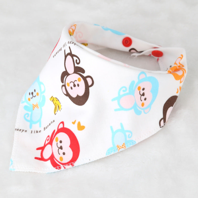 White baby bib with colorful cartoon monkeys and bananas. Blue, brown, red patterns on a soft fabric with pink and red button closures. Text reads “Monkeys like Banana.”