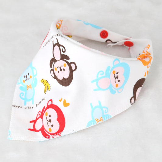 White baby bib with colorful cartoon monkeys and bananas. Blue, brown, red patterns on a soft fabric with pink and red button closures. Text reads “Monkeys like Banana.”