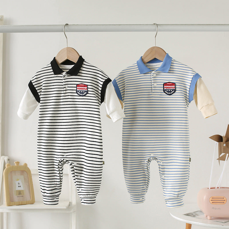 Two baby onesies hang on a rail. One has black and white stripes with a black collar, and the other has blue and white stripes with a blue collar. Both have a patch on the chest.