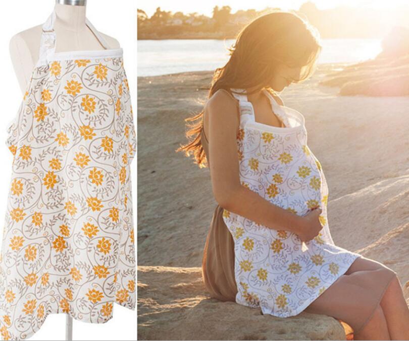 Pregnant woman wearing a floral-patterned apron, sitting on a rock by the beach at sunset. The apron, shown on a mannequin on the left, is white with yellow flowers.
