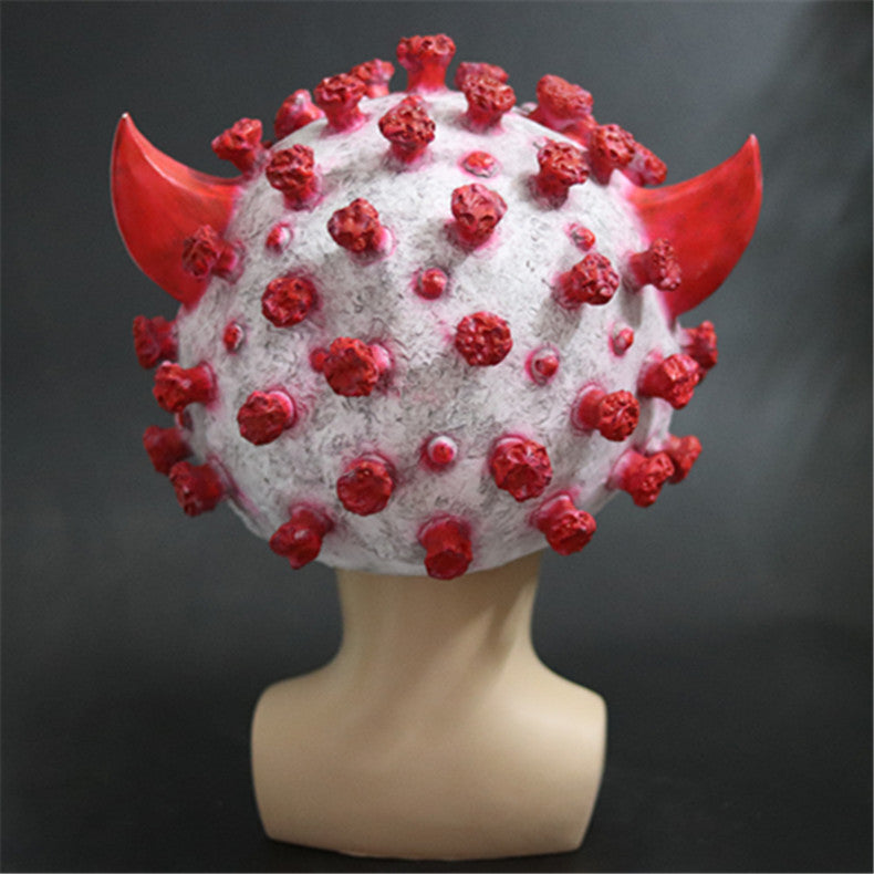 A humanoid mannequin head displays a COVID-19 virus-inspired mask with red spikes and devil horns on a dark background, highlighting the virus theme in a creative way.