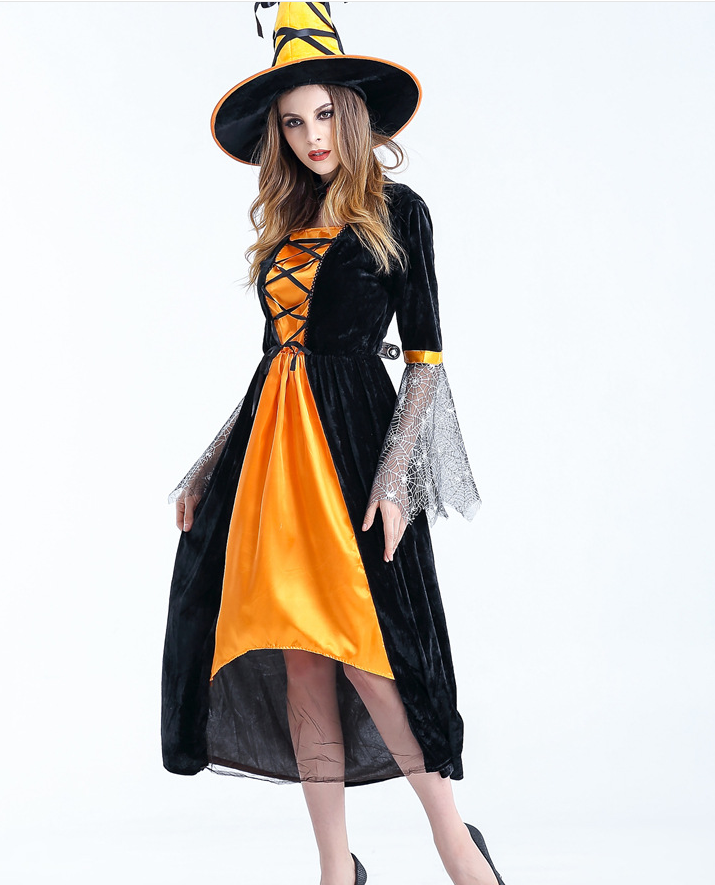 Woman in a black and orange witch costume with lace sleeves and a pointy hat, posing against a plain background. The dress features a crisscross front detail.