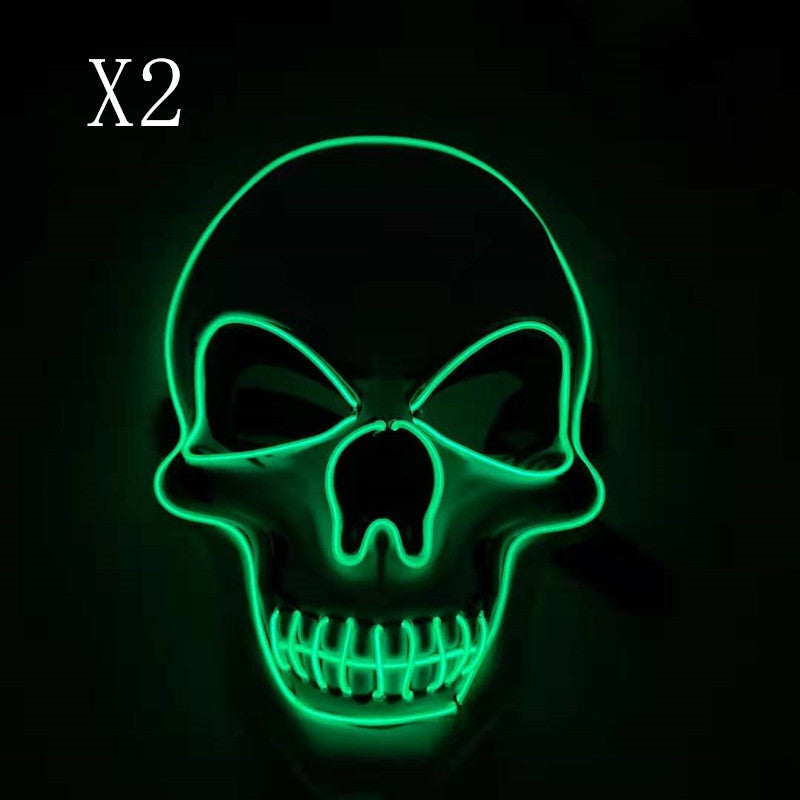 Glowing green neon skull sign with hollow eyes and exposed teeth on a dark background, accompanied by text "X2" in the top left corner.
