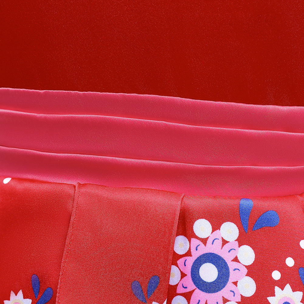 Close-up of a red fabric with floral patterns in pink, white, and blue. Pink satin ribbon accents provide contrast, creating a vibrant and colorful textile design.