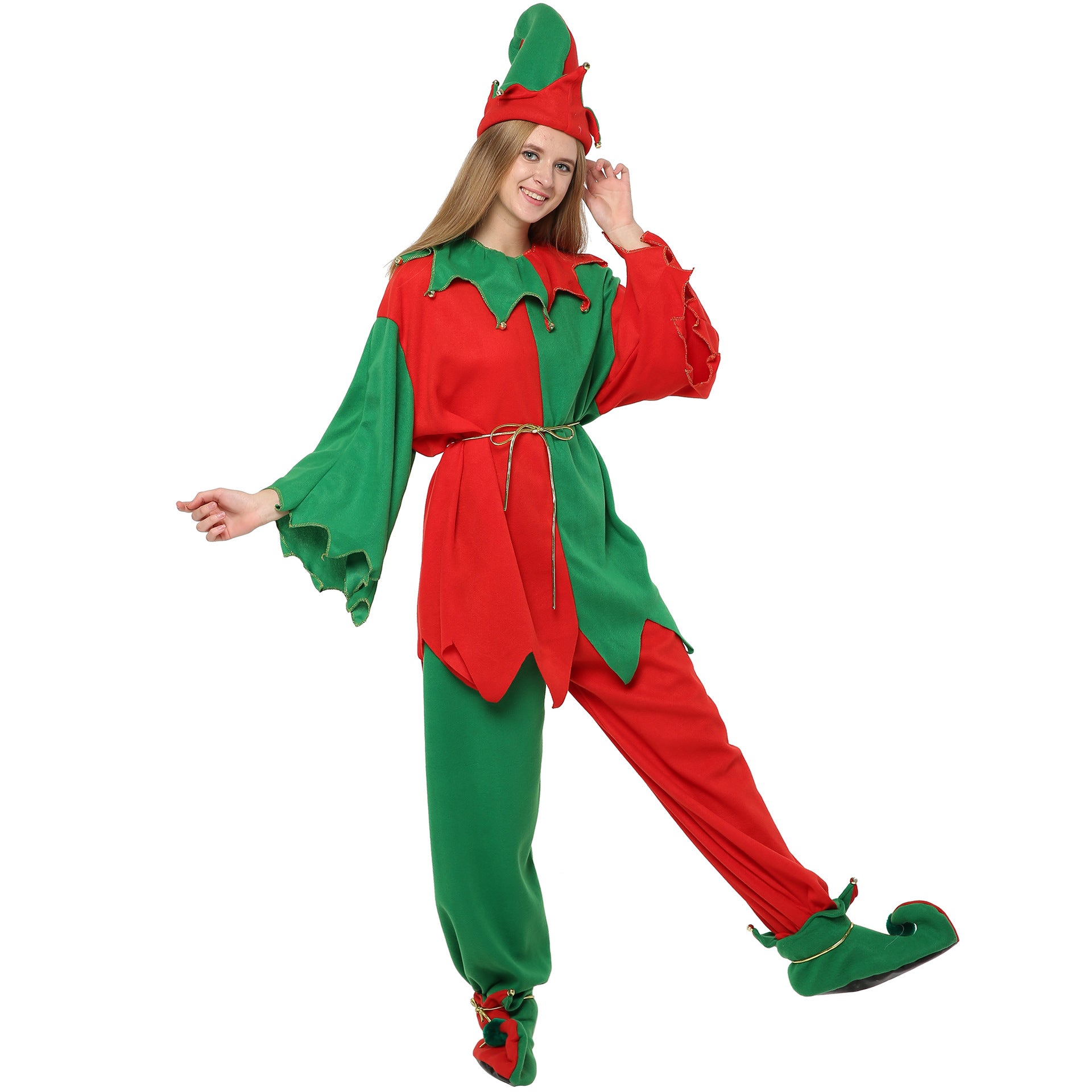 Smiling person wearing a festive elf costume in red and green, including a pointed hat, belted tunic, and curly-toed shoes, striking a playful pose on one foot.