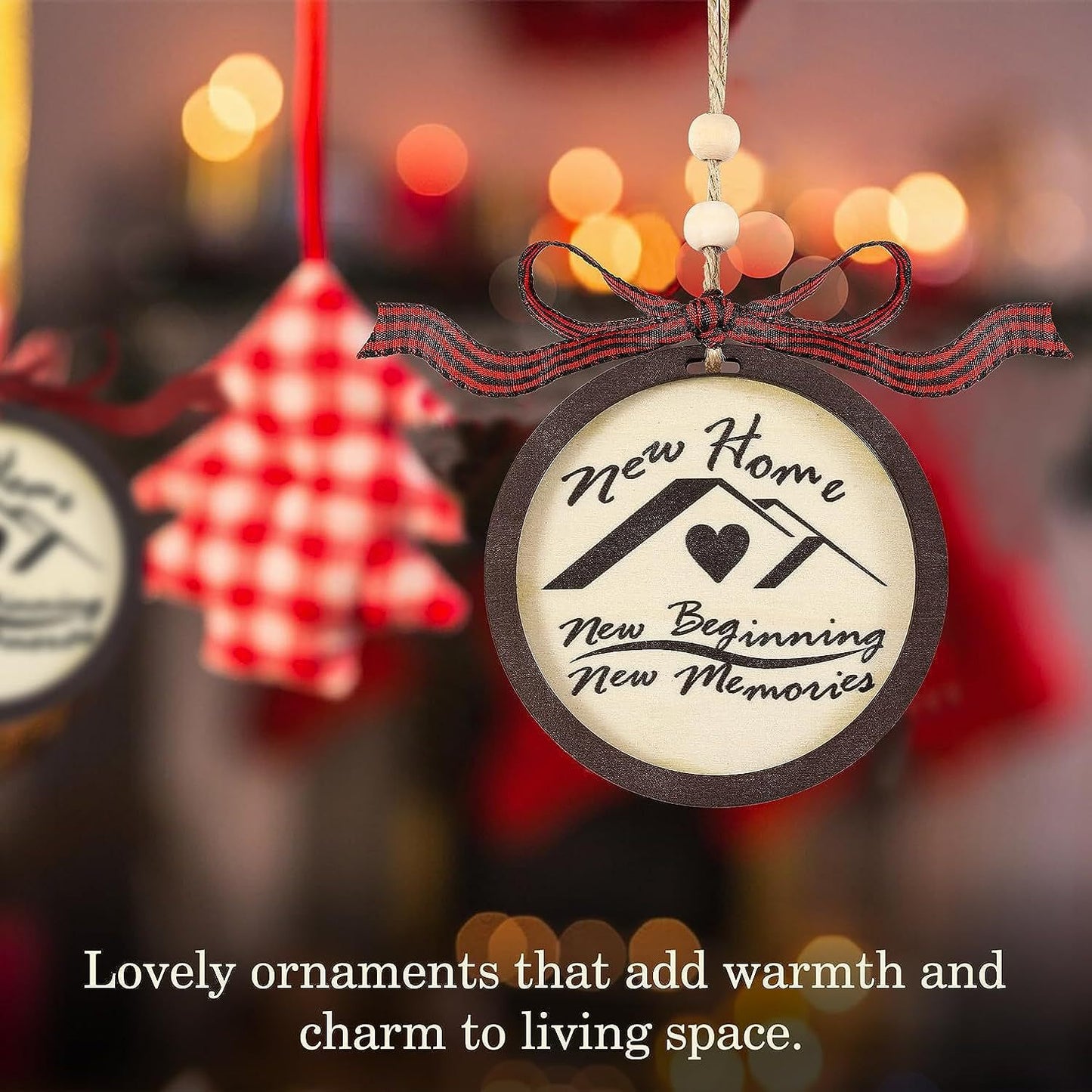 A round ornament with "New Home, New Beginning, New Memories" text, adorned with a heart and red-and-black ribbon, hangs amidst blurred lights and a checkered star decoration.