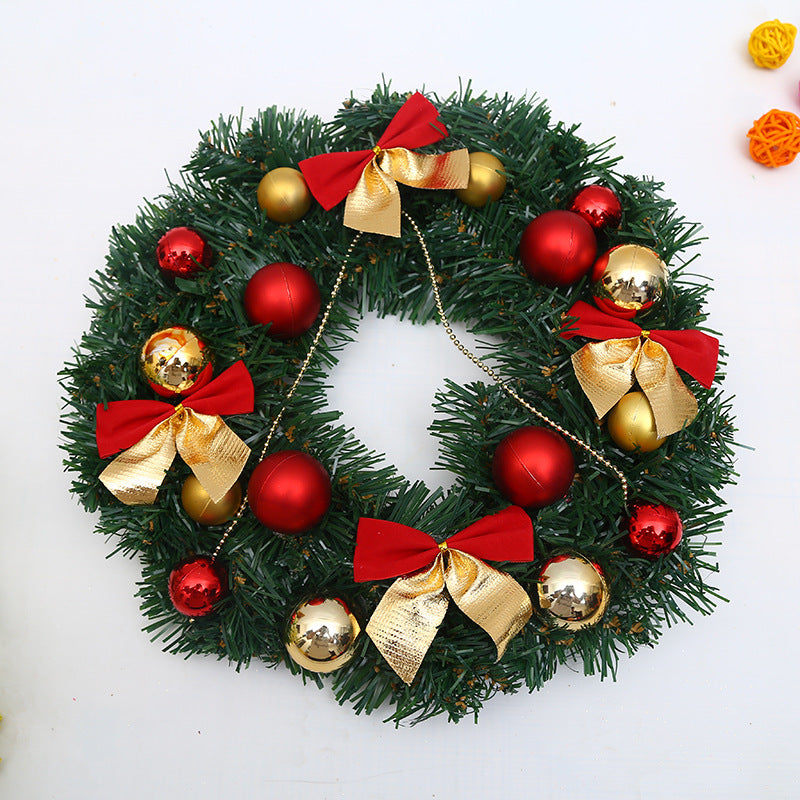 Festive Christmas wreath adorned with red and gold baubles, red and gold bows, and golden bead chains against a white background, with colorful rattan balls nearby.
