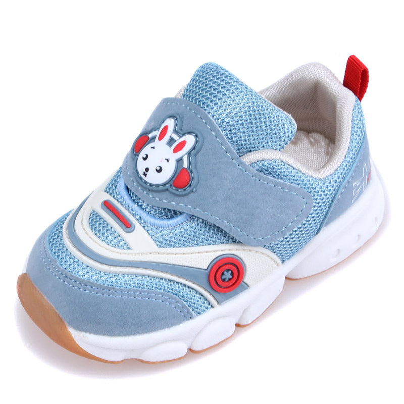Blue and white children's sneaker with a bunny design on the Velcro strap, red accents, and a non-slip sole. Features contrast stitching and a red loop on the heel.