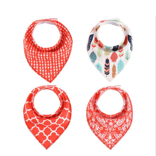 Four baby bandana bibs are displayed, each with a different pattern: red arrows, colorful leaves and feathers, red geometric shapes, and red floral swirls.