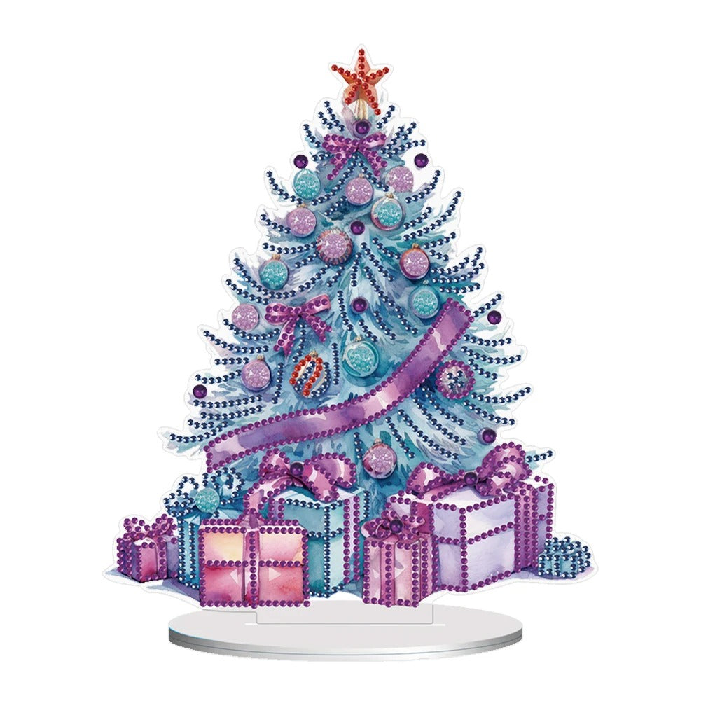 Festive tree with blue and pink ornaments, a purple ribbon, and a star topper. Surrounded by purple and pink wrapped gifts on a white background.