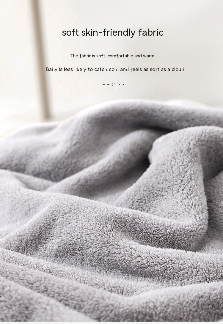 Close-up of soft, plush gray fabric with text describing its skin-friendly, comfortable, and warm qualities, ideal for keeping babies warm and feeling like a cloud.