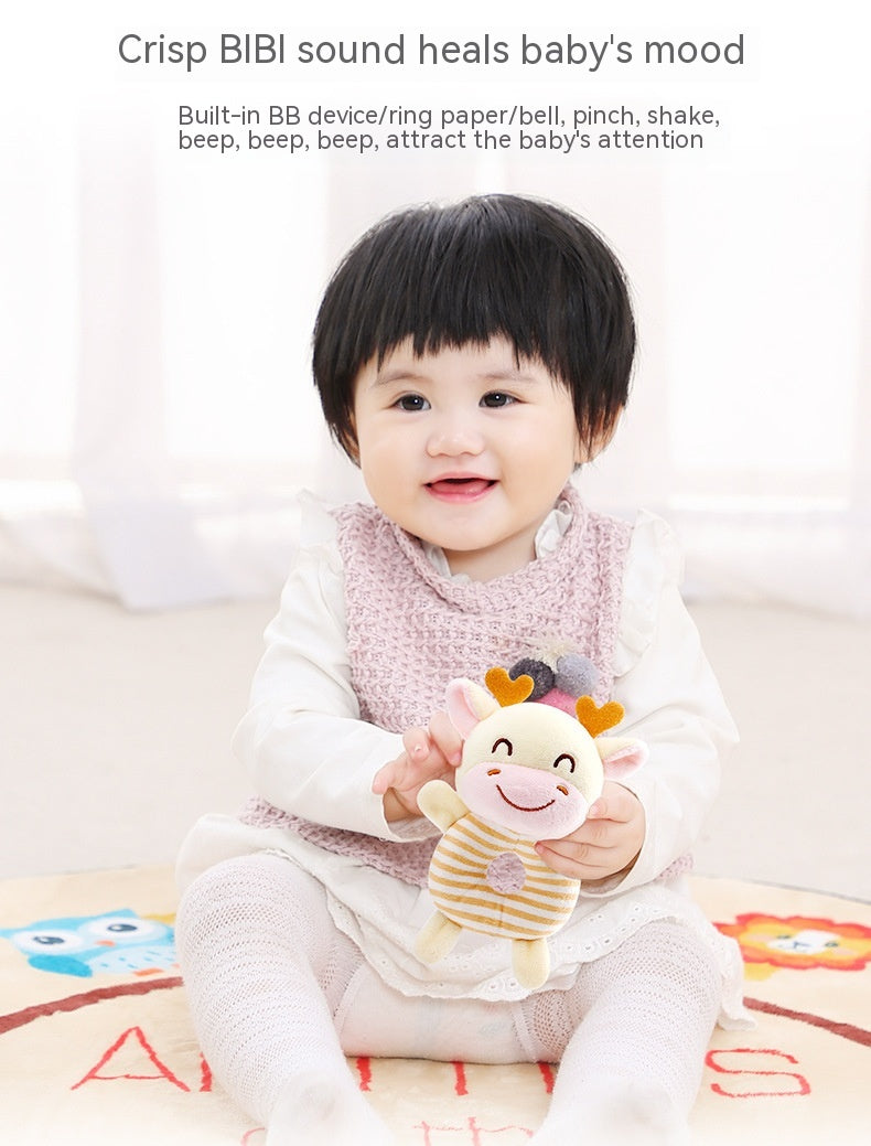 Baby sitting on a mat, holding a smiling stuffed toy. The toy features soft colors and playful design to capture attention, accompanied by text about calming sounds for babies.