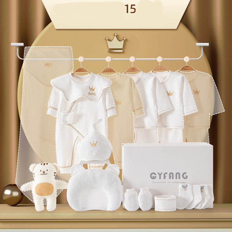 A set of white baby clothes and accessories with crown designs hang on a rack. Includes bodysuits, a hat, socks, a pillow, a plush toy, and a white box labeled "CYFANG."