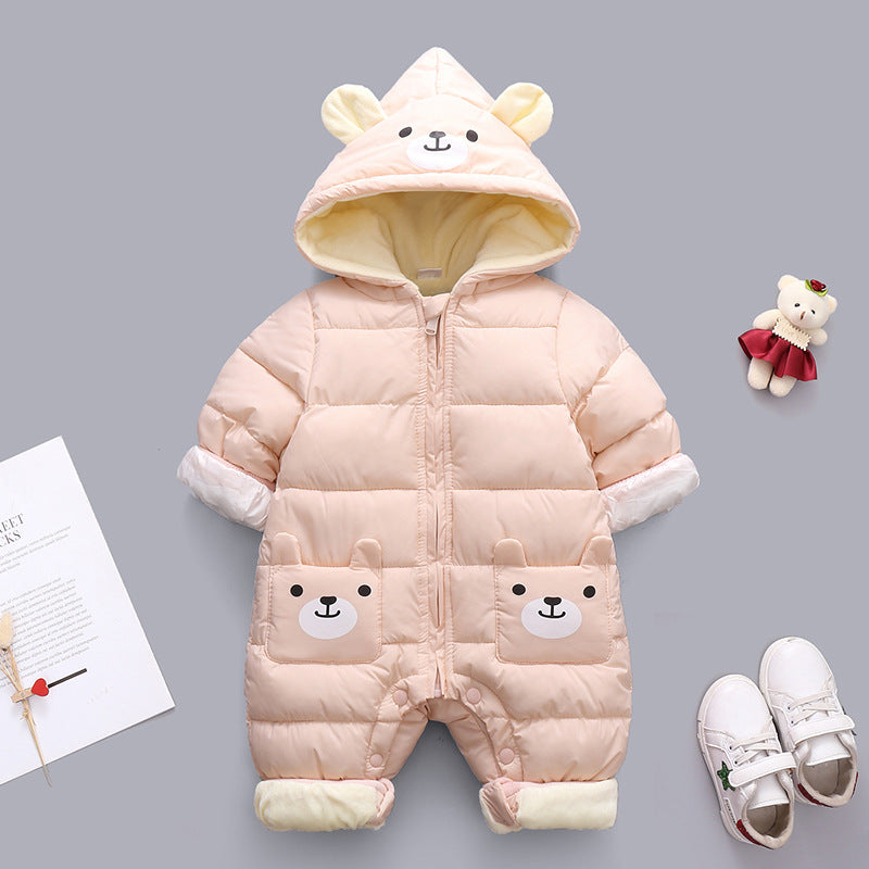 Pink baby snowsuit with bear face on hood and pockets, featuring fold-over cuffs and footies. Paired with white shoes and a small teddy bear toy, all on a gray background.