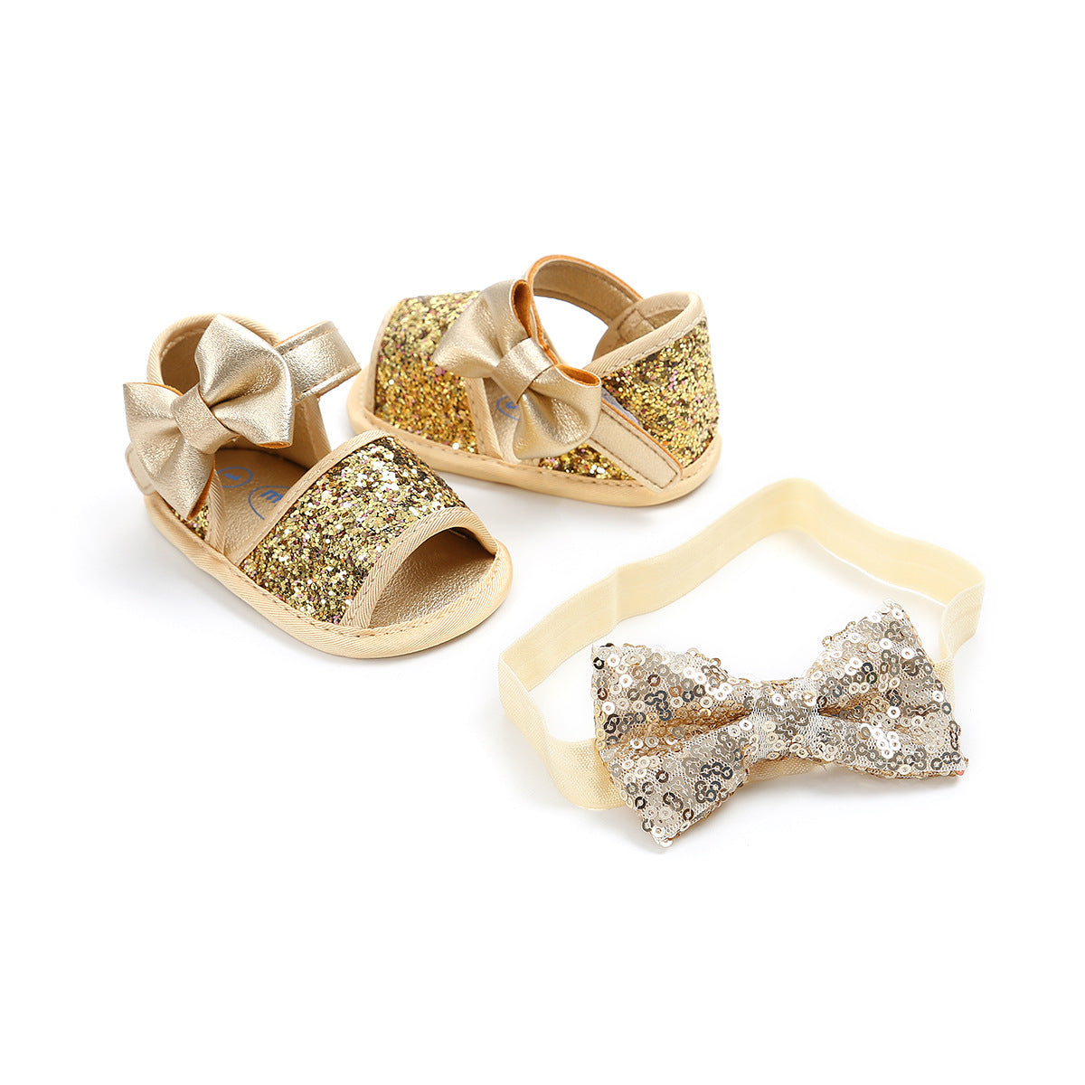 Gold glitter baby sandals with large bows, paired with a matching sequin bow headband, set on a white background.