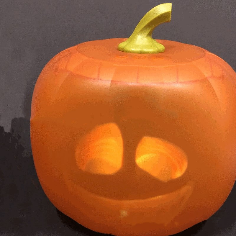 A glowing, carved pumpkin jack-o'-lantern with a toothy grin and a short green stem, set against a dark background, casting a warm internal light.