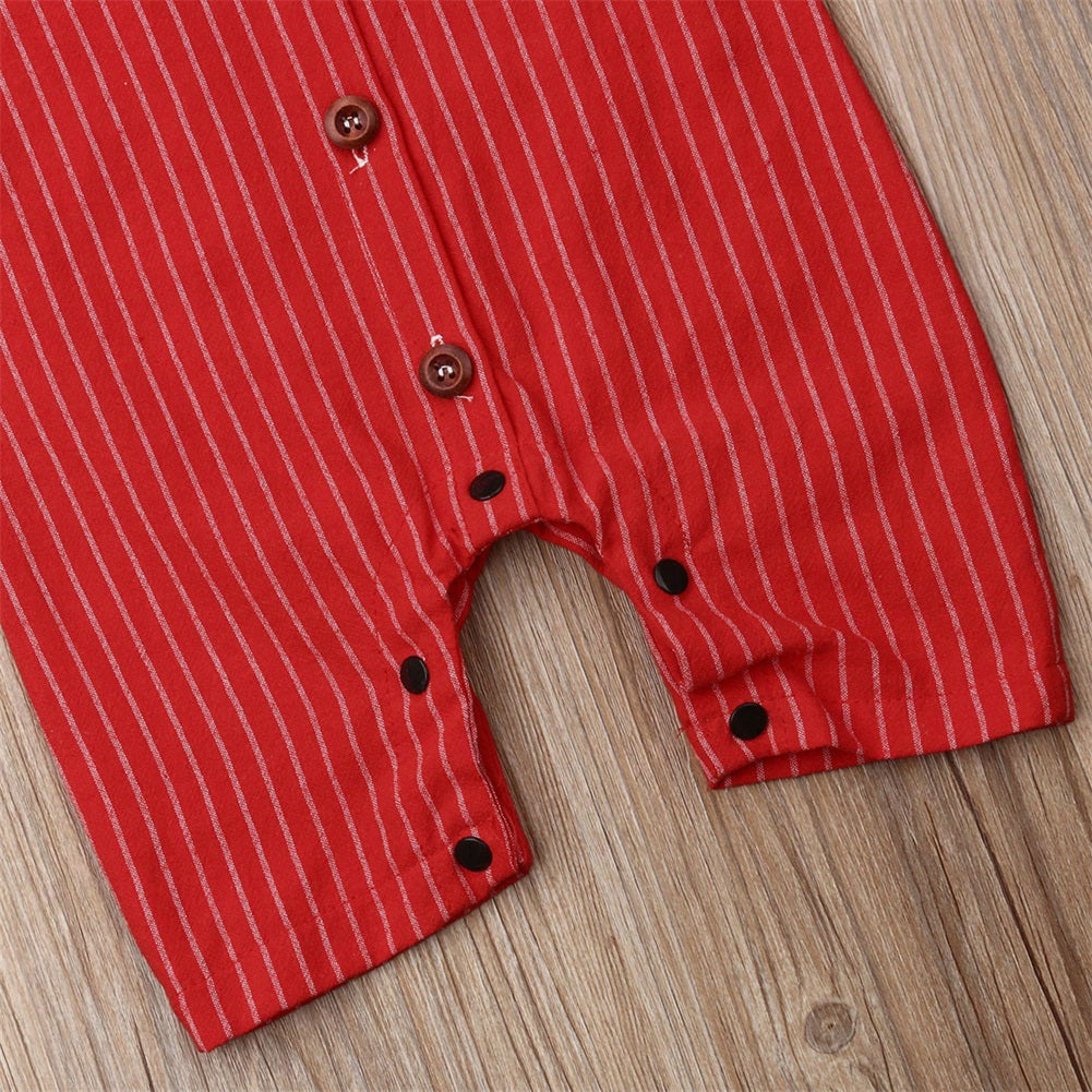 Close-up of red striped baby pajamas with brown buttons and black snap closures on a wooden surface. The fabric features thin vertical grayish stripes for a classic look.