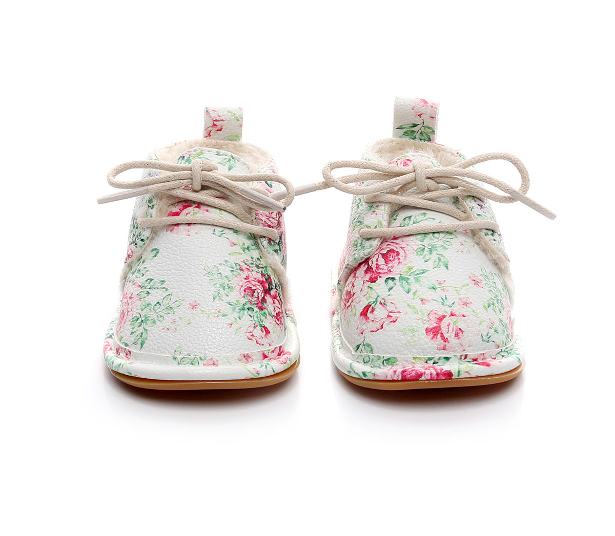 Baby shoes with a floral pattern on a white background. The shoes feature pink and green flowers, beige laces, and a soft inner lining, suitable for toddlers.
