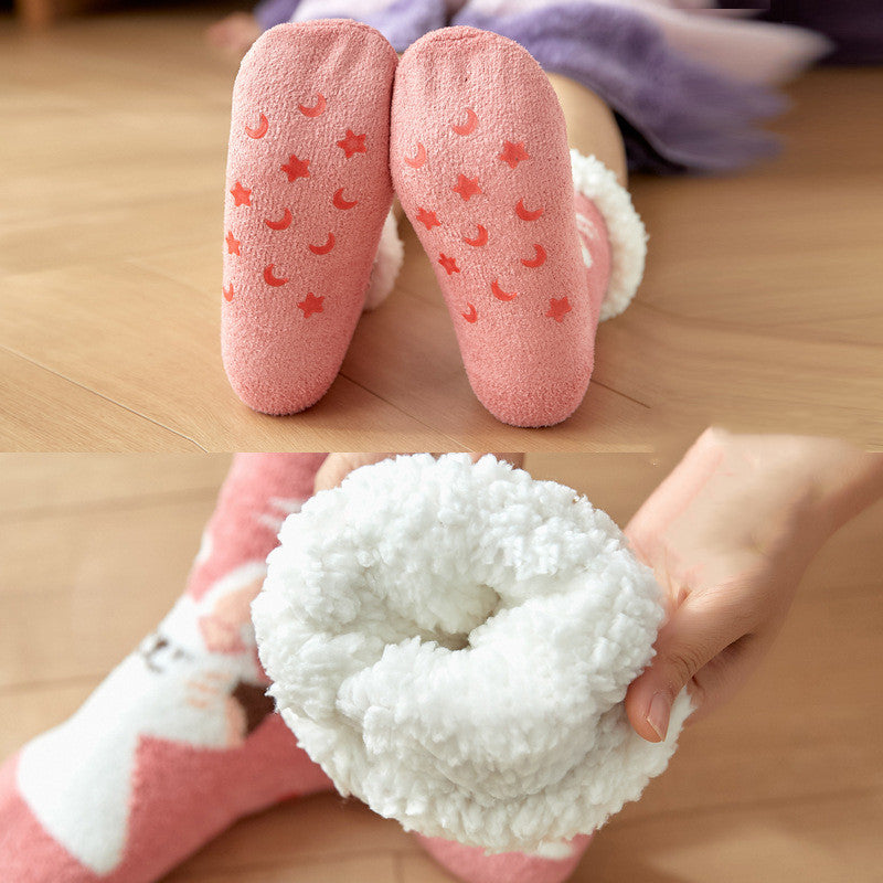 Close-up of pink fuzzy socks with non-slip star and moon patterns. The inner lining is soft and fluffy white. One hand holds a rolled-up sock.
