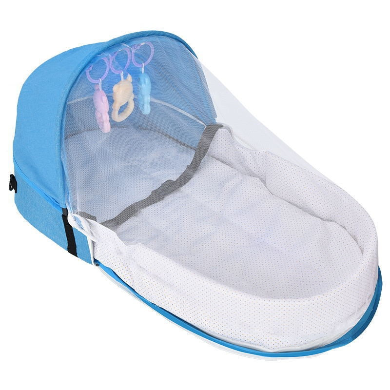 Blue baby bassinet with a detachable canopy and mosquito net. Features three colorful hanging toys and a soft, white mattress. Ideal for infant comfort and safety.