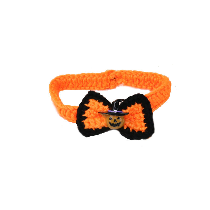 Orange crocheted pet collar with a black-edged bow tie featuring a small jack-o'-lantern charm dressed as a witch, ideal for Halloween festivities.