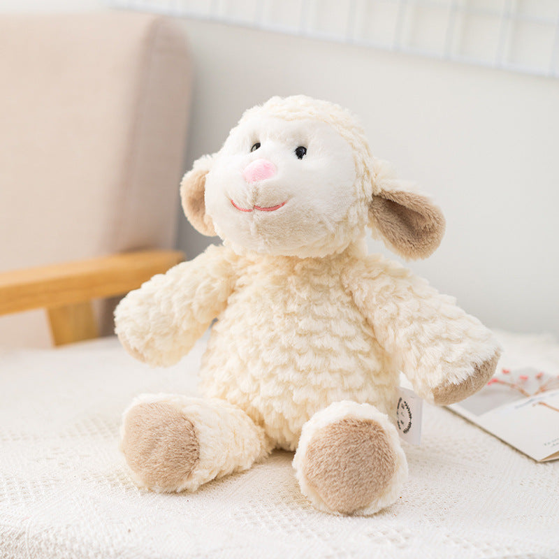 Plush lamb toy with curly cream fur and brown ears, nose, and feet, sits on a textured white surface near a beige chair, exuding a cute and cozy vibe.