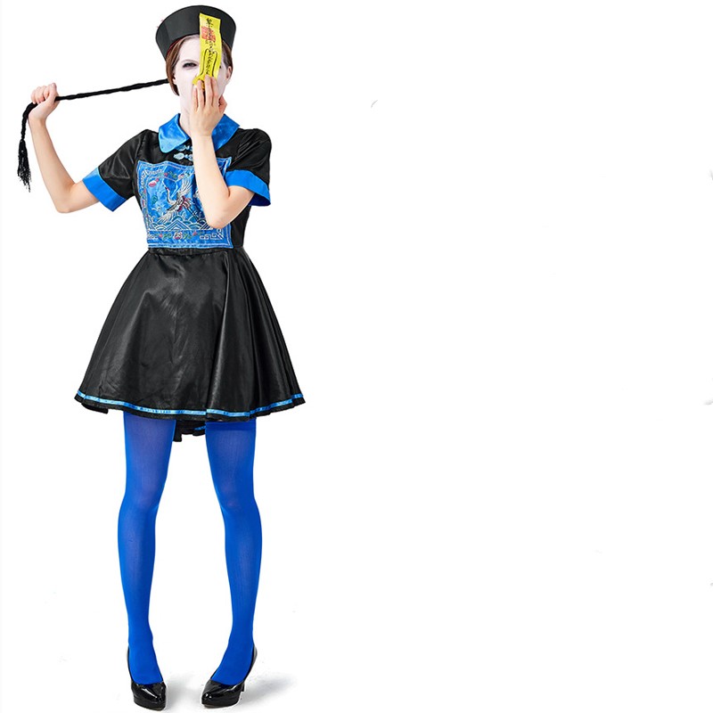 Person in a black and blue traditional costume, with blue leggings and a black hat, holds a yellow talisman over their face while pulling a long braid with the other hand.