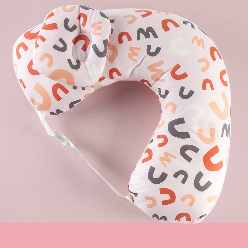 Colorful U-shaped pillow with multicolored pattern on a pastel pink background, featuring an adjustable strap and a small attached circular cushion for added comfort.