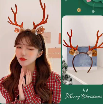 Woman with wavy hair wearing a red plaid shirt and reindeer antler headband, winking. Beside her, a close-up of the headband, decorated with flowers, displayed against a Christmas-themed backdrop.