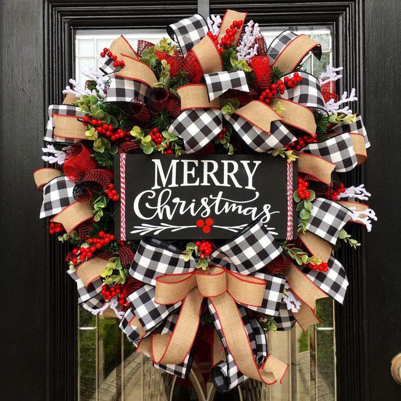 Festive Christmas wreath with red berries, greenery, and black-and-white checkered ribbons. A central black sign reads "Merry Christmas."