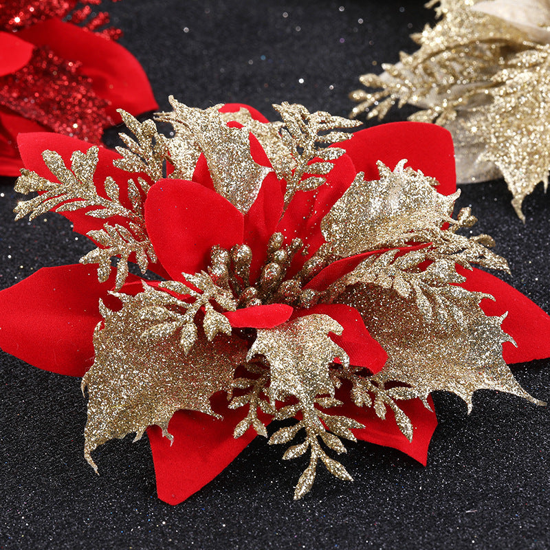 Red poinsettia with gold glittered leaves on a dark surface, creating a festive and elegant holiday decoration.