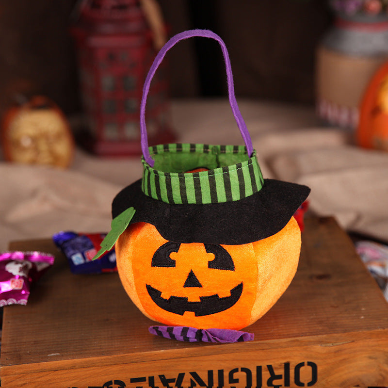 Halloween pumpkin basket with a smiling jack-o'-lantern face, wearing a striped witch hat. It sits on a wooden crate surrounded by Halloween decorations and candy.