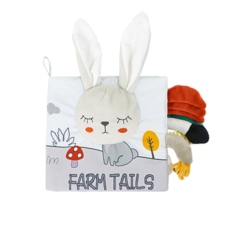 Soft fabric book with a bunny face and ears on the cover, labeled "Farm Tails." Colorful animal tails protrude from the right side, adding tactile elements for children.