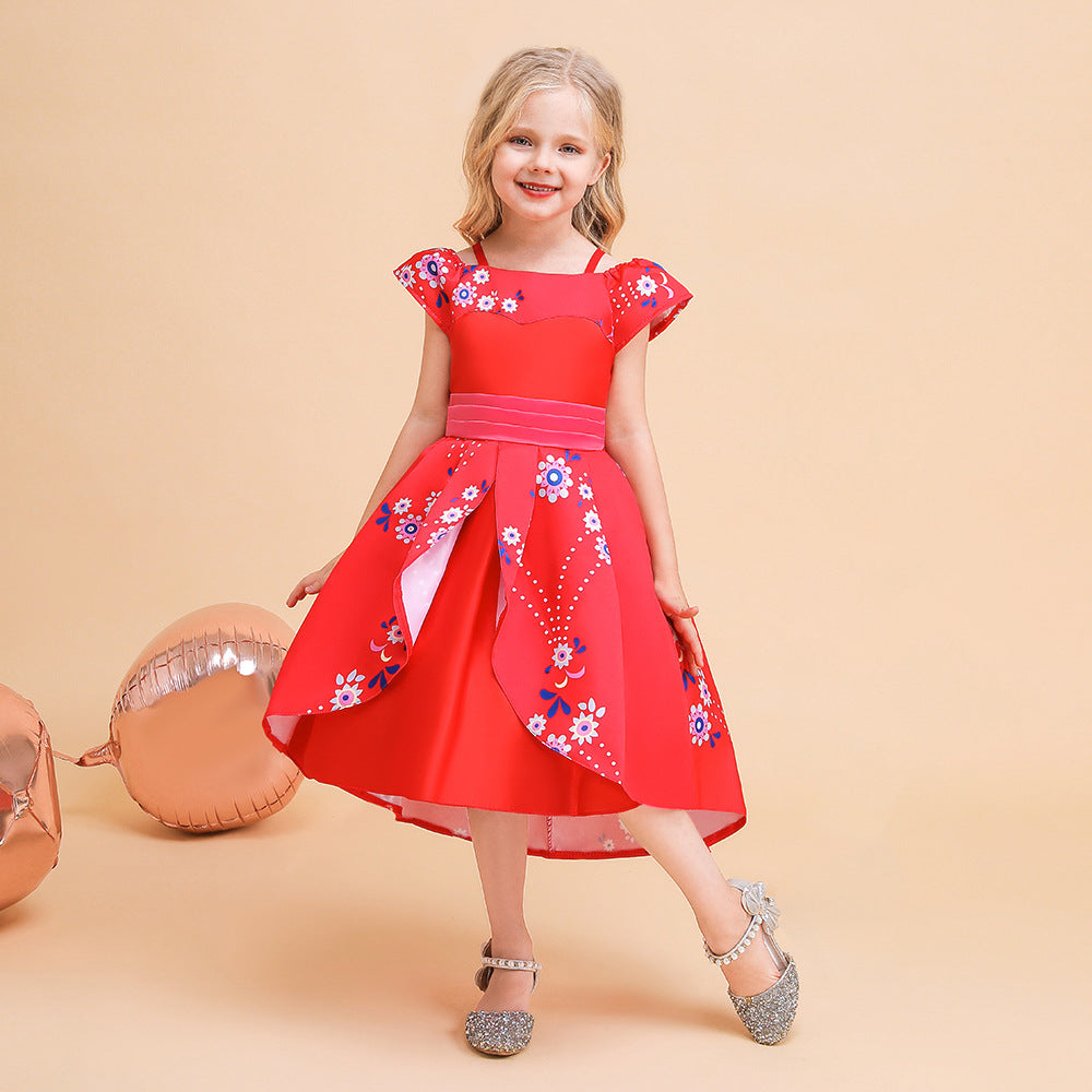 A smiling young girl in a red floral dress with ruffled sleeves and pink sash stands on a peach background near rose gold balloons, wearing glittery silver shoes.