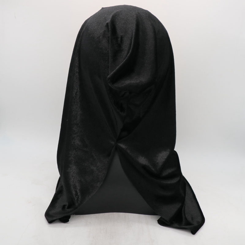 A black velvet cloth draped over an unidentified object on a neutral, light-colored background. The fabric has a shiny, smooth texture with a slight gathering near the bottom.