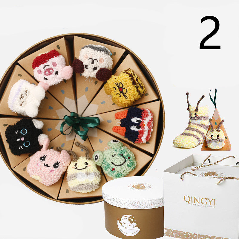 Circular gift box with colorful character-themed socks arranged in pie-shaped sections. Includes an outer box with "Qingyi" logo and an additional pair of yellow snail socks.