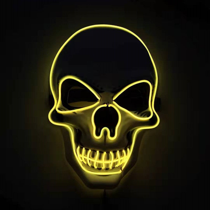 Glowing yellow neon skull sign on a dark background, featuring sharp eyes and a toothy grin, creating an eerie, Halloween-themed atmosphere.