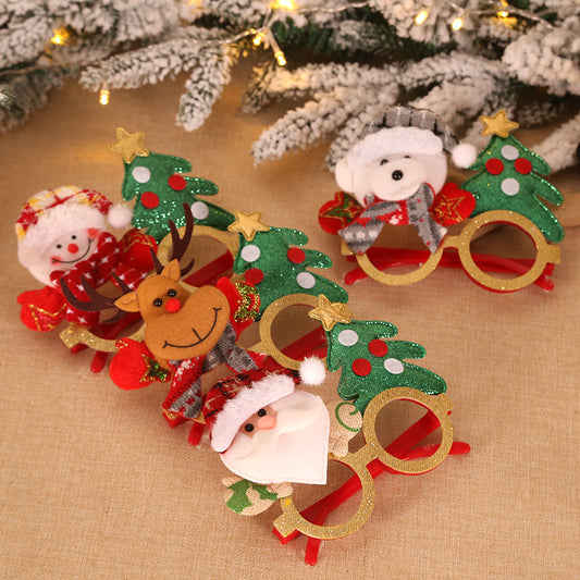 Festive novelty glasses featuring Christmas decorations, including a snowman, reindeer, and Santa, surrounded by green trees with red and white accents, on a beige surface.