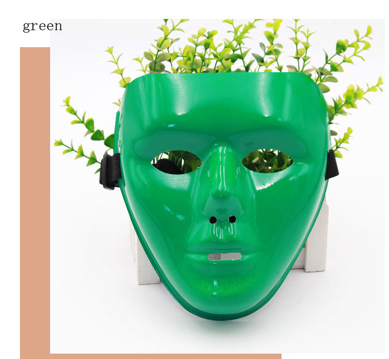 Green face mask with strap displayed against white background, partially covering a plant with small green leaves. "Green" text in top left corner.