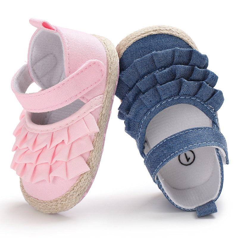 Pink and blue baby shoes with ruffled fabric and Velcro straps, designed for comfort and style, resting against each other on a white background.