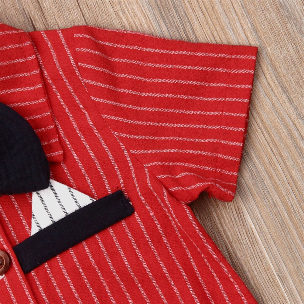 Close-up of a red striped shoulder of a shirt with short sleeves on wooden background. The shirt features a black collar and pocket detail with contrasting black and white patterns.