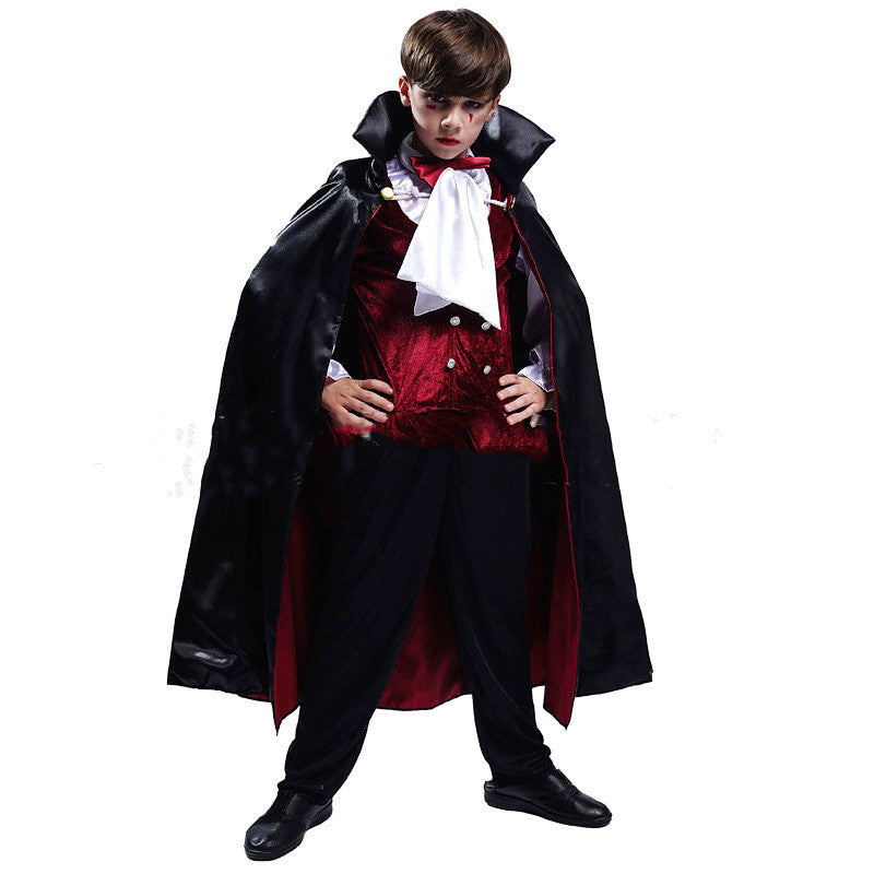 Young boy dressed as a vampire, wearing a black cape with a red lining, a red vest, white shirt with ruffled collar, black pants, and black shoes, standing confidently.