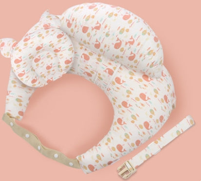 Multifunctional nursing pillow with a whimsical animal print in soft orange and beige hues on a peach background. It includes adjustable straps for secure positioning.