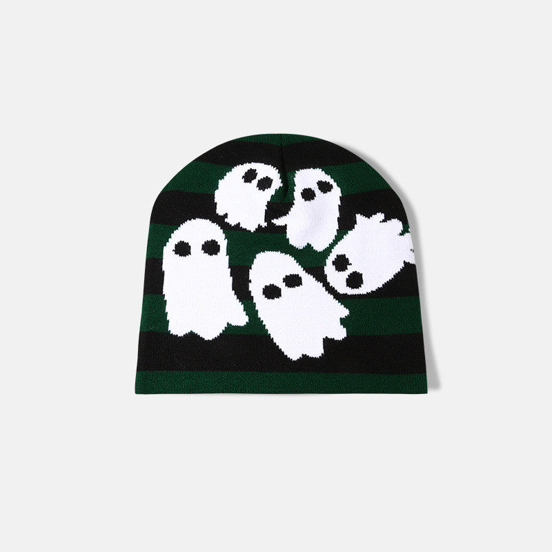 A black and green striped beanie featuring cute white ghost illustrations with black eyes. The playful design adds a whimsical touch to this cozy winter accessory.