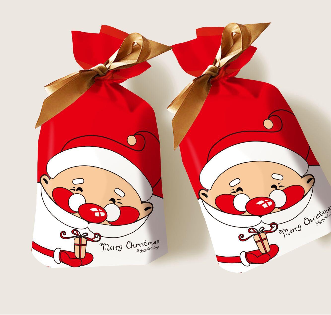 Two red gift bags featuring a cartoon Santa holding a small gift, tied with gold ribbons. The bags display "Merry Christmas" in decorative text.