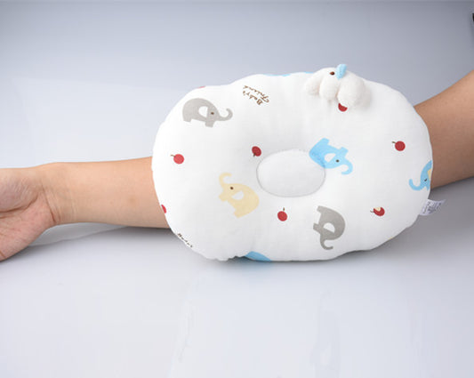 Arm resting on a white cushion with colorful elephant and red dot patterns, featuring a small pillow for elbow support.