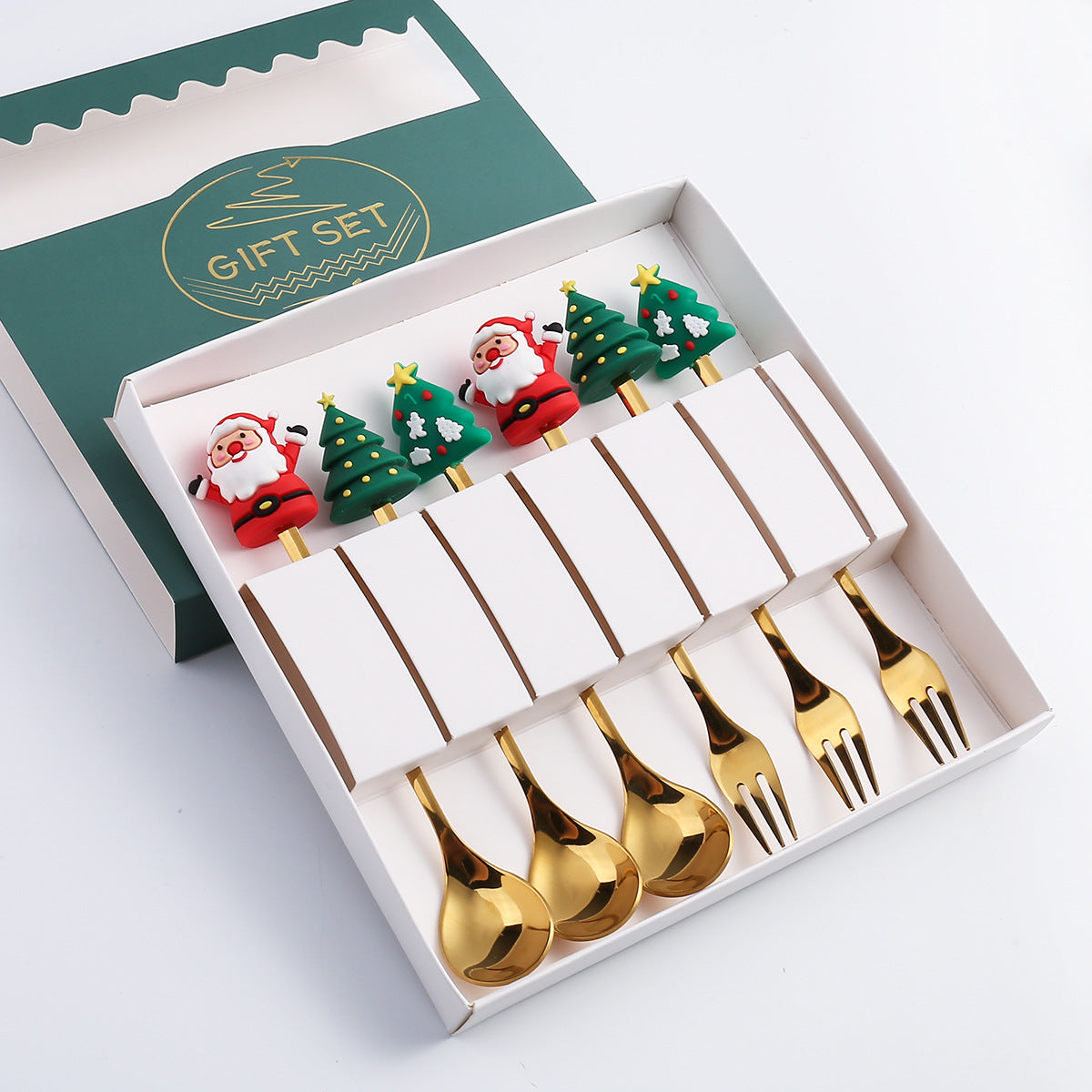 Gift set of gold spoons and forks with festive Santa and Christmas tree handles, displayed in a white and green box with "Gift Set" written in gold on the lid.