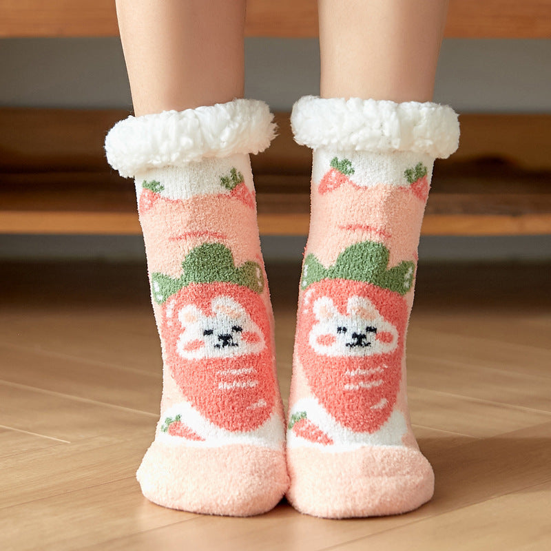 Cozy pink socks with fluffy white cuffs featuring cute cartoon strawberries with animal faces. The design is playful and perfect for keeping feet warm on wooden flooring.